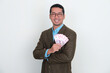 © KrishnaTedjo - Asian businessman wearing suit smiling while holding money