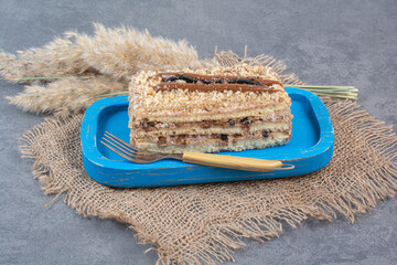 Wall Mural - A piece of creamy cake on blue plate with fork