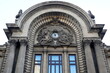 Architectural details of CEC Palace facade on Calea Victoriei boulevard in center of Bucharest. Semicircular pediment with stone sculpture depicting Mercury and Demetra deities
