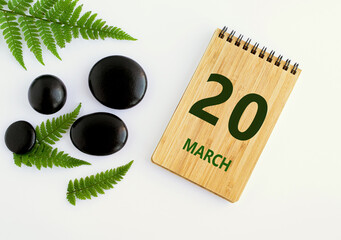 Wall Mural - March 20. 20th day of the month, calendar date. Notepad, black stones, green leaves. Spring month, the concept of the day of year