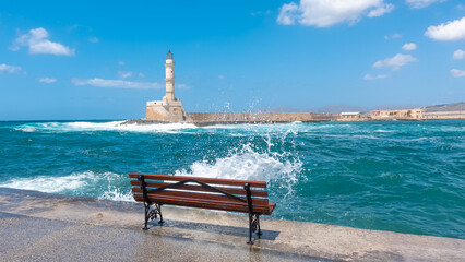 Wall Mural - Vue d'un banc avec une vague sur le port de Chania en Crète.	