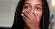 Child shocking reaction to news, black ethnicity girl suprised covering mouth with hand