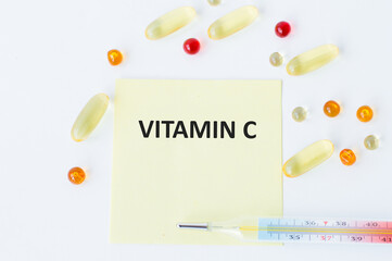 Wall Mural - A card with text VITAMIN C on a table with a pills and pencil, medical concept, top view