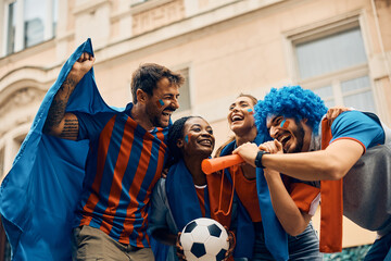Wall Mural - Group of cheerful soccer fans celebrate their favorite team's victory on street.