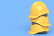 Stack of safety helmets or hard caps for carpentry work on blue background