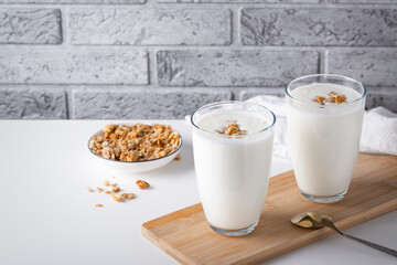 Wall Mural - Kefir, buttermilk or yogurt with granola. Yogurt in glass on light background.