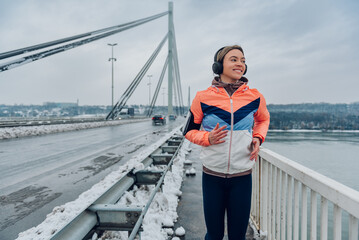 Wall Mural - Woman running on the bridge at winter and snow.