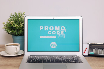 Canvas Print - Laptop with activated promo code on wooden table indoors