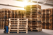 Modern Manual Forklift And Wooden Pallets In Warehouse