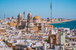 Rooftops of houses in aerial view of the medieval city of Cádiz and towers and cupula of Cathedral de la Santa Cruz in seafront, SPAIN