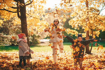 happy family throwing autumn leaves