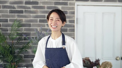 Leinwandbilder - 接客するエプロンをつけた女性　花屋　店員