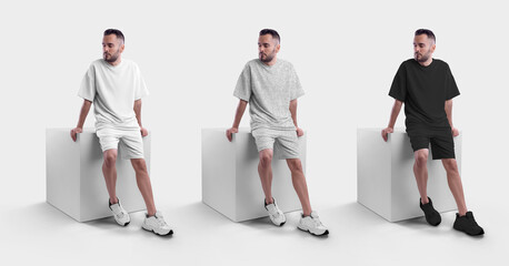 Wall Mural - Mockup of a white, black and gray men's oversized t-shirt with shorts on a man on a cube.