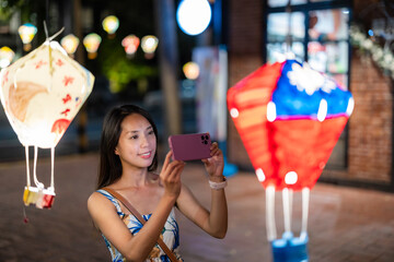 Wall Mural - Tourist woman use mobile phone to take photo in Tiehua Village of Taitung