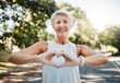 © K Abrahams/peopleimages.com - Fitness, happy and heart hands of old woman in nature after running for health, wellness and workout. Smile, motivation and peace with senior lady and sign for love, faith and training in nature
