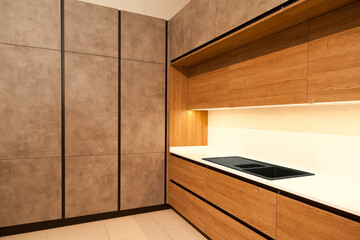 Wall Mural - Modern brown wood oak kitchen cabinet equipment and granite black sink in a home