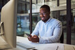 © N Lawrenson/peopleimages.com - Social media phone, night work and businessman reading an email on smartphone while working in a dark office at night. Corporate African manager in communication on mobile app while doing overtime