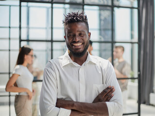 Portrait of smiling African American business man with executives working in background