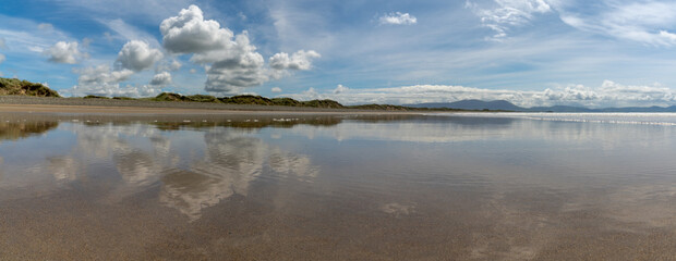 Poster - panorama landscape of an empty golden sand beach with reflections of sky and sand dunes