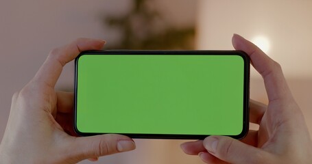 GREEN SCREEN CHROMA KEY CU Caucasian female using generic smart phone, horizontal orientation, modern apartment interior background