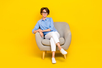 Sticker - Full length photo of charming pretty girl dressed blue shirt eyewear relaxing sofa isolated yellow color background