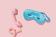 Creative Layout With Pink Retro Phone Handset And Sleep Mask With False Eyelashes On Pastel Pink Background. 80s Or 90s Retro Fashion Aesthetic Telephone Concept. Romantic Handset Cosmetic  Idea.
