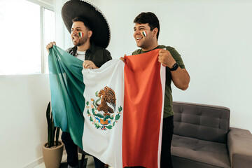 Wall Mural - Football fans friends watching Mexico national team in live soccer match on TV at home