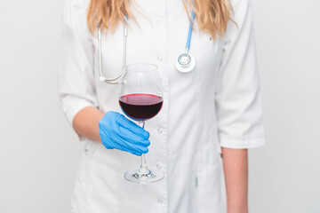 a glass of wine in the hands of a doctor or scientist. concept - health benefits of wine.