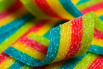 Sticker - Colorful jelly candies strips in sugar sprinkles. Sour flavored rainbow candy background.