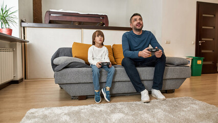 Wall Mural - Caucasian little boy and father playing video game