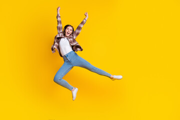 Sticker - Full length photo of shiny lucky girl dressed plaid shirt jumping high rising fists isolated yellow color background