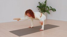 Close-up Of A Woman Making Balance Yoga Pose In White Sportswear To Be Healthy