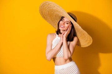 Wall Mural - Photo of shiny adorable lady wear white outfit hat arms hands cheek cheekbone closed eyes isolated yellow color background