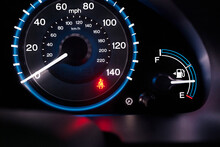 A Lit Up Car Dashboard, Mph Speed Dial, In Miles And Kilometres, Fuel Guard And A Red Warning Seatbelt Light.