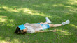 © junky_jess - Slow life. Caucasian woman lying on the grass in shavasana pose with a book on her face in the public park outdoor in summer, selected focus.