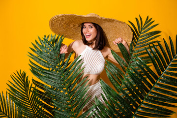 Poster - Photo of shiny funny lady wear white set headwear holding palms leaves isolated yellow color background