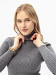 Woman in grey knitted turtleneck on white background