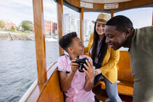 Happy Family With Digital Camera On Tourist Boat On River