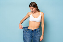 Woman Astonished With Results Of Her Slimming And Weight Loss Pulling Large Oversize Jeans