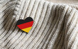 © Nikita - Flag of the Germany in the shape of a heart on warm woolen things. The concept of winter in Germany.