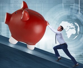 Man pushing piggybank uphill in business concept