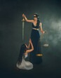 Fantasy portrait woman goddess of other world dead weighs soul a sinner on scales, against an ostrich's feather. Sinner girl prays on knees for forgiveness mercy salvation. Greek Themis holding sword