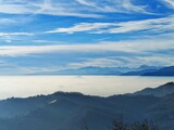 Fototapeta  - Fog on the plain of Friuli and view of Piancavallo and the Alps at sunset from Mount Bernadia in Tarcento