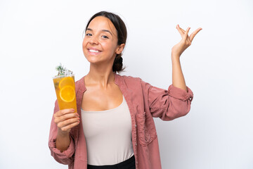 Wall Mural - Young hispanic woman holding a cocktail isolated on white background extending hands to the side for inviting to come