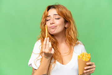 Wall Mural - young caucasian woman holding fried chips isolated on green screen chroma key background