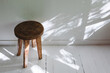 Wooden stool near the white wall, rustic interior details.