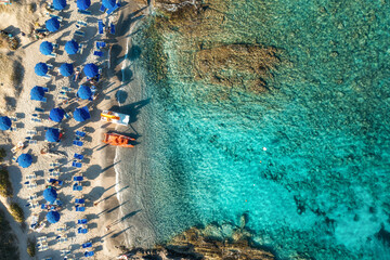 Wall Mural - Top view of beautiful seascape. Aerial view of sandy beach with colorful umbrellas and blue water. Sardinia, Italy