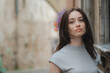 © Michele Ursi - Beautiful Ukrainian girl with red hair, blue eyes and freckles in a grey summer dress leaning with his back against a wall in a cobbled street with street lamps in the old town