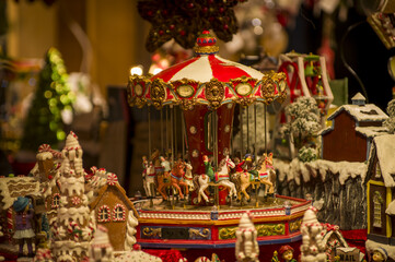 Advent Bazaar Stalls with glass, wooden, ceramic christmas souvenirs in shops. Close up of festive decorations for tree in winter street night market during new year's holiday. Illuminated fair kiosk