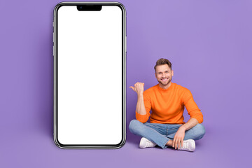 Poster - Photo of good mood man sitting floor point thumb modern technology placard promo isolated on purple color background